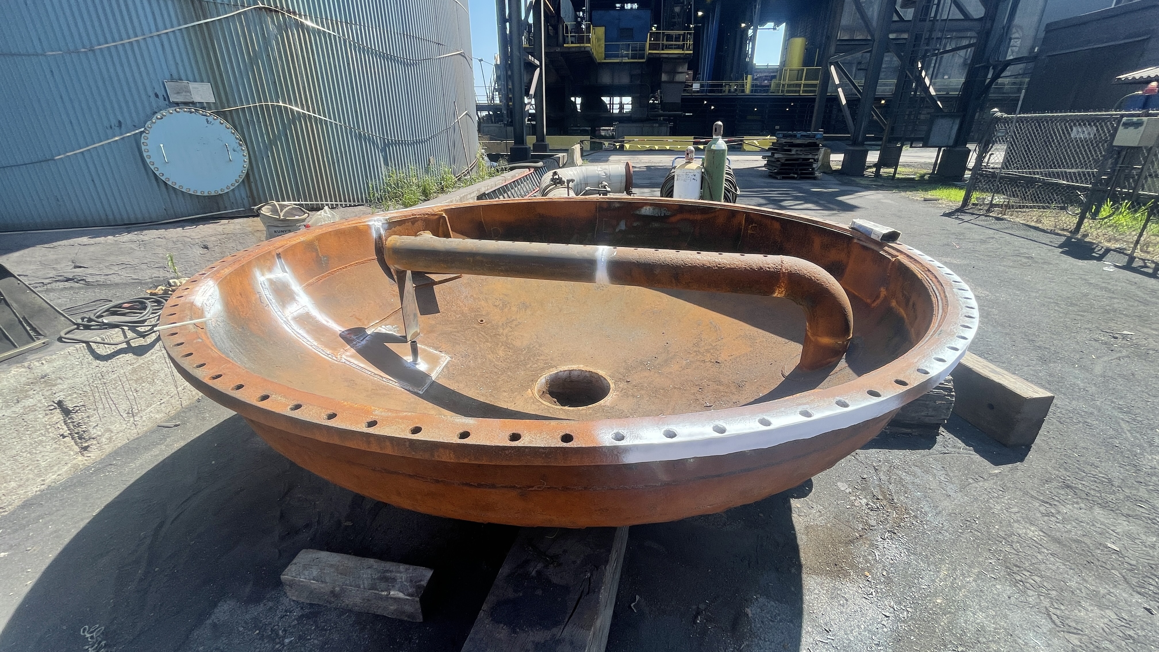 Fabricated pressure vessel head with bolted flange, staged for inspection