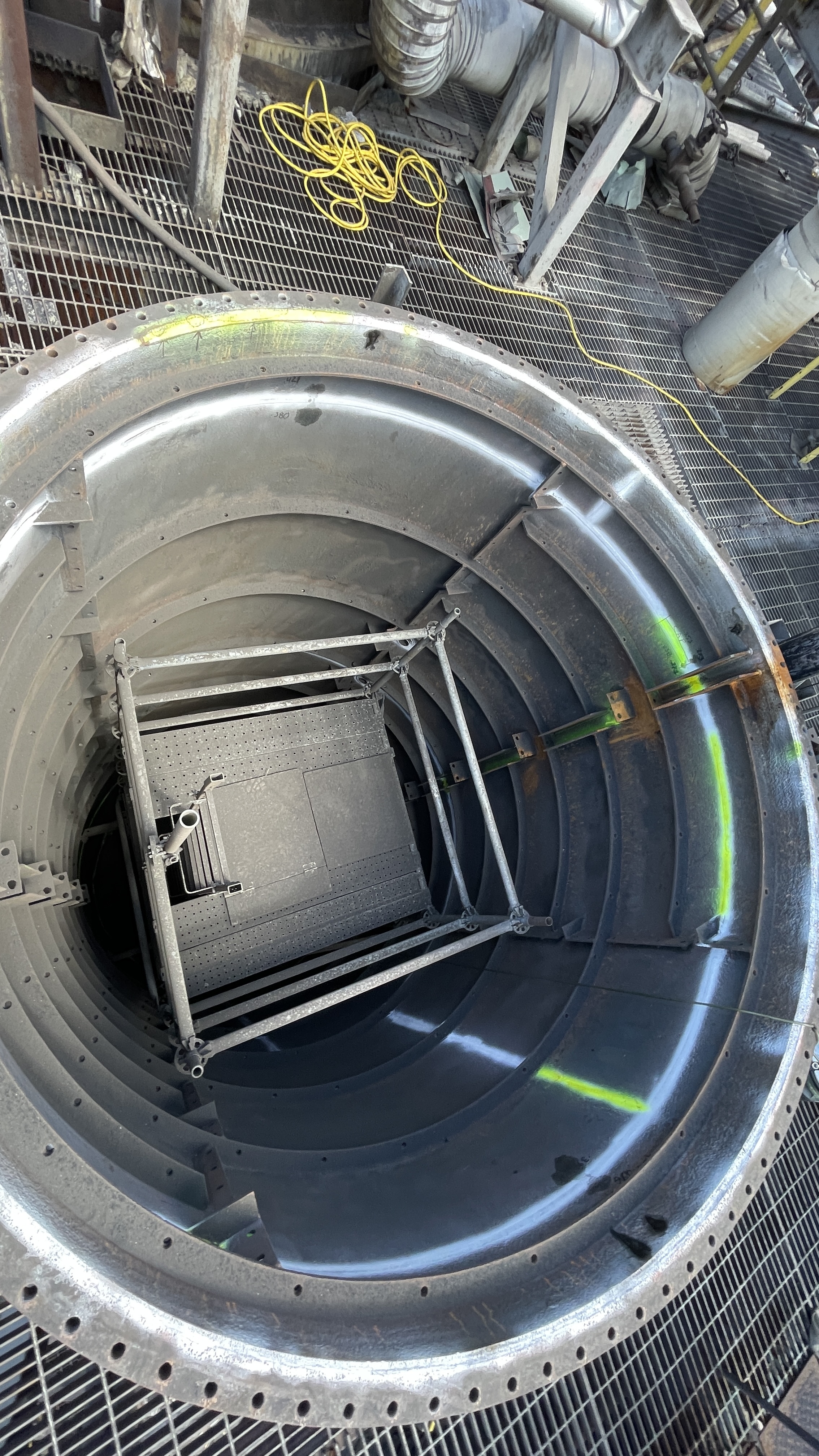 WMI inspector's access platform inside a large riveted industrial vessel during an internal inspection